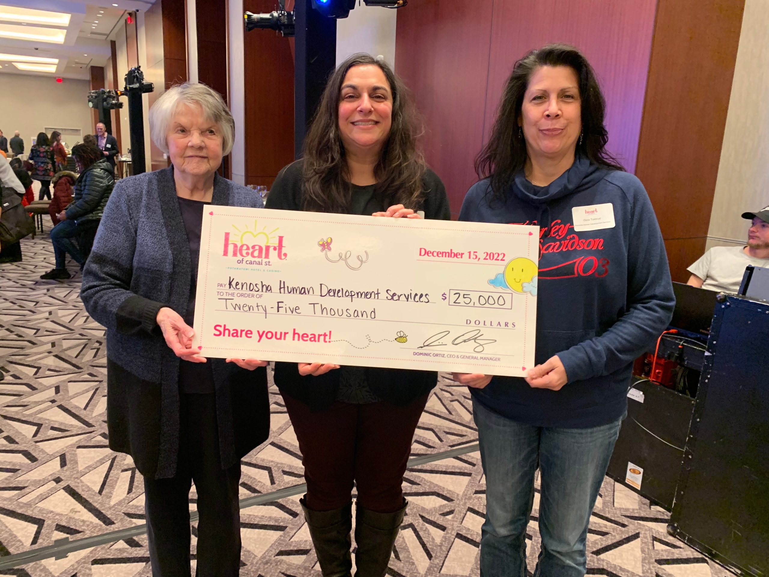 Sue, Lisa and Gina holding a sign showing a $25,000 donation from the Heart Foundation.